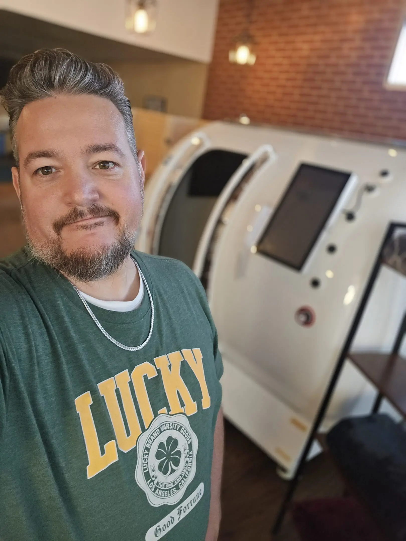 Person wearing Lucky shirt beside hyperbaric pod