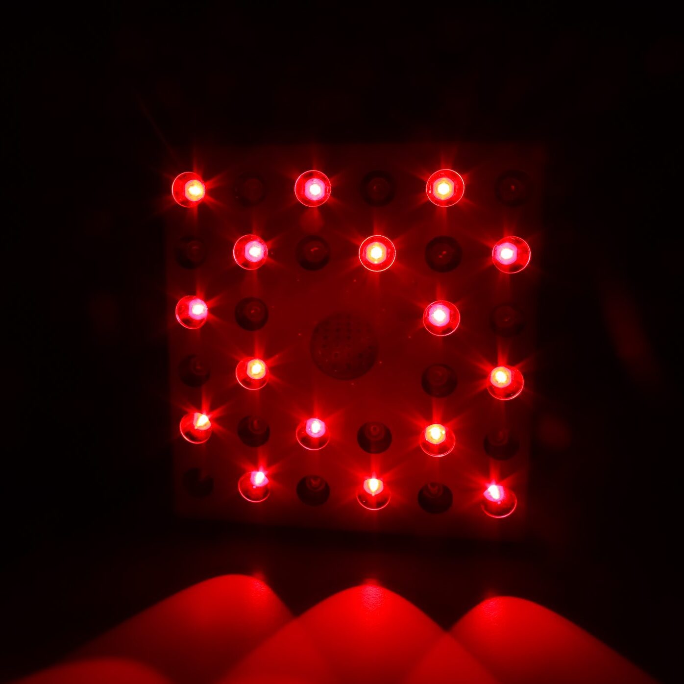 A glowing red infrared panel radiates bright light in a dimly lit environment, emphasizing technological innovation and modern lighting designs, captured in a vivid visual display.